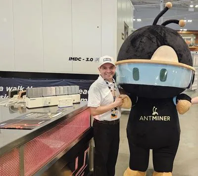 Aviran Vargas with Antminer mascot at the Bitmain booth